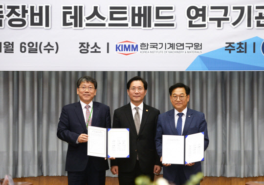 산업통상자원부는 6일 대전 한국기계연구원에서 15개 공공 연구기관, 국내 소재·부품·장비 기업 대표들을 초청한 가운데 간담회를 열고 테스트베드 확충 방안을 논의했다. 이날 성윤모 산업부 장관(가운데)이 배석한 가운데 김영삼 전자부품연구원장(오른쪽)과 박천홍 기계연구원장이 소재·부품·장비 기술협력에 관한 양해각서를 들이보이고 있다. <산업통상자원부 제공>